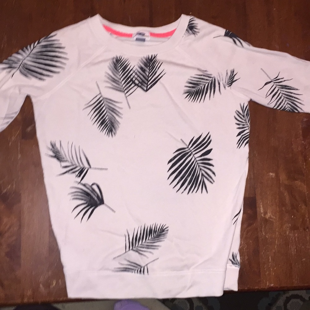 White long sleeve shirt with black leaves .